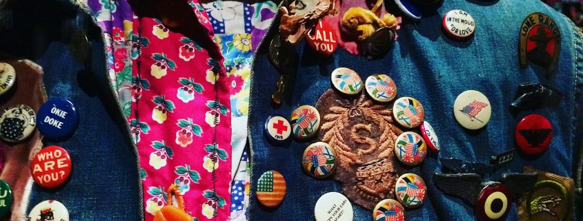 colourful shirt and denim jacket with pin badges